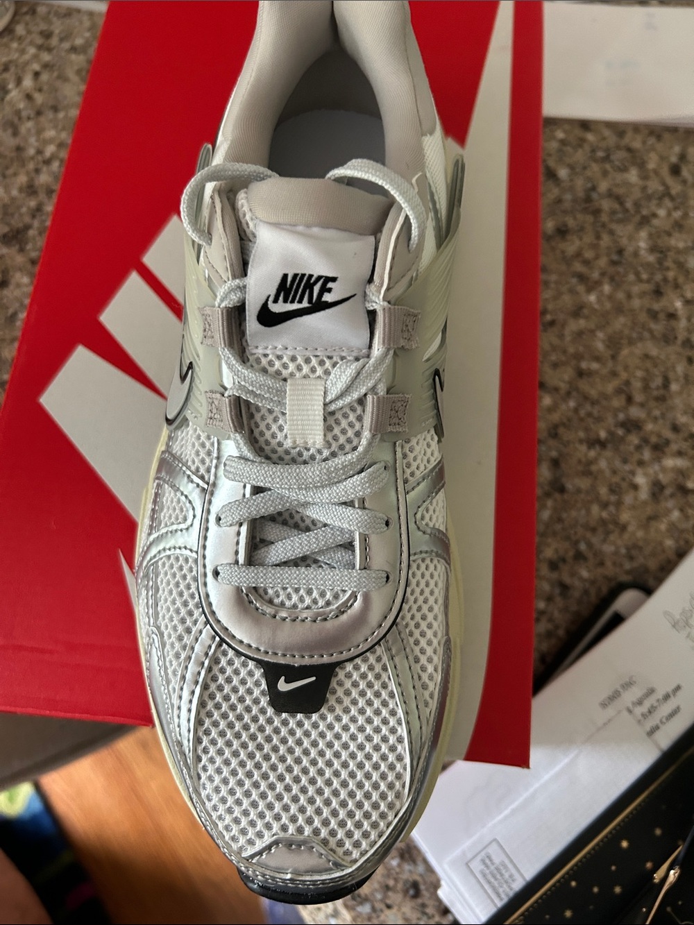 Nike white sneaker with silver metallic detail.